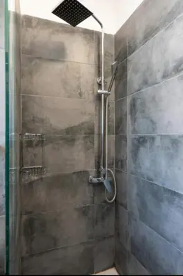 a shower with a glass door in a bathroom at Koukaki Hideaway Suite in Athens