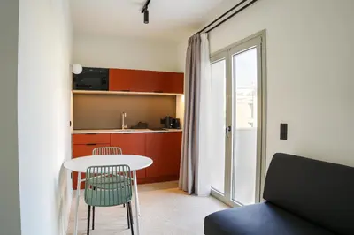 a room with a table and a kitchen with red cabinets at Mooeve Psyri in Athens