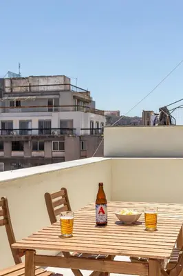 a wooden table with a bowl of food and a bottle of beer at Mooeve Psyri in Athens