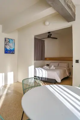 a bedroom with two beds and a table and a chair at Mooeve Psyri in Athens