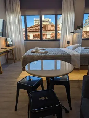a hotel room with a bed and a table and a bed at Triple A - Psiri Fruit Market Artistic Studios - FREE Parking in Athens