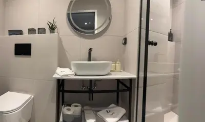 a bathroom with a sink and a toilet and a mirror at Triple A - Psiri Fruit Market Artistic Studios - FREE Parking in Athens