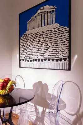 a table with chairs and a picture of a building at Synathens Syntagma Apartments in Athens