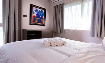 a bedroom with three towels on a white bed at Synathens Syntagma Apartments in Athens