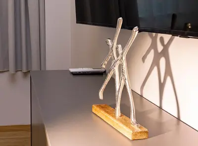 a wooden sculpture on a table with a laptop at Synathens Syntagma Apartments in Athens