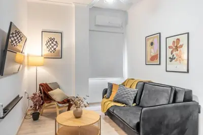 a living room with a black couch and a table at Nobe Acropolis Suite in Athens