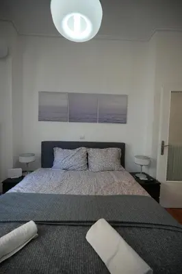 a bedroom with a large bed and a large light at The Cozy Studio, Nea Smyrni in Athens
