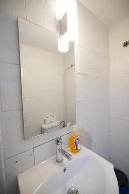 a white bathroom with a sink and a mirror at The Cozy Studio, Nea Smyrni in Athens