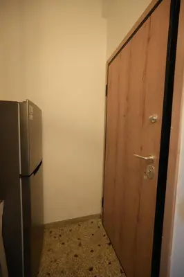 a room with a door and a refrigerator in it at The Cozy Studio, Nea Smyrni in Athens