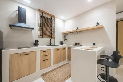 a kitchen with a white counter and a black chair at Exarcheia Luxury Apartment in Athens