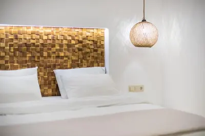 a bedroom with a white bed with a wooden headboard at Exarcheia Luxury Apartment in Athens