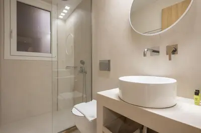 a white bathroom with a sink and a shower at Exarcheia Luxury Apartment in Athens