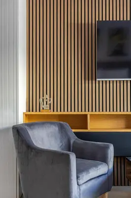 a blue chair in a living room with a television at Aether Residences in Athens