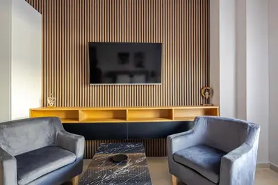 a living room with two chairs and a tv at Aether Residences in Athens