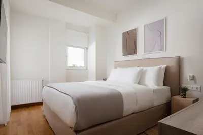 a white bedroom with a large bed with white pillows at Athenian Riviera Coastal Charm Villa in Athens