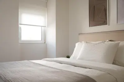 a white bedroom with a bed with a window at Athenian Riviera Coastal Charm Villa in Athens