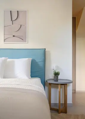 a bed with a blue headboard next to a table at Athenian Riviera Coastal Charm Villa in Athens