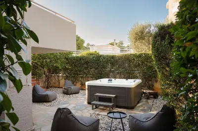 a backyard with a hot tub and some chairs at Athenian Riviera Coastal Charm Villa in Athens