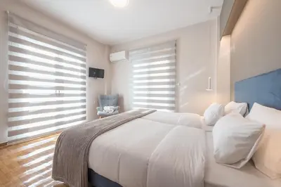 a white bedroom with a large bed with white pillows at Dream Athens Stay Cozy 3BR with balcony in Athens