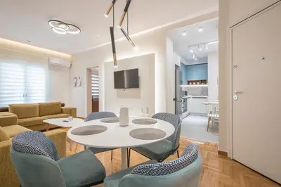 a dining room and living room with a table and chairs at Dream Athens Stay Cozy 3BR with balcony in Athens
