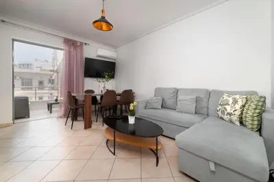 a living room with a couch and a table at 3BA next to metro and Athens city center with view in Athens