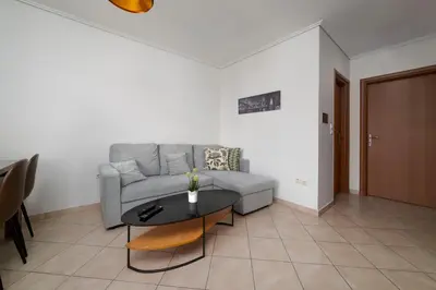 a living room with a couch and a table at 3BA next to metro and Athens city center with view in Athens