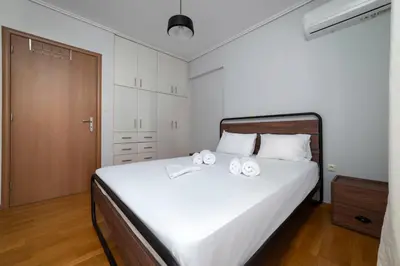 a bedroom with a bed with two towels on it at 3BA next to metro and Athens city center with view in Athens