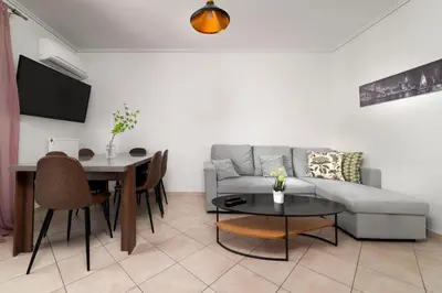 a living room with a couch and a table at 3BA next to metro and Athens city center with view in Athens