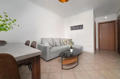 a living room with a couch and a table at 3BA next to metro and Athens city center with view in Athens