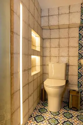 a bathroom with a toilet and a tiled floor at 1001 Nights - Low Celling Studio in downtown in Athens