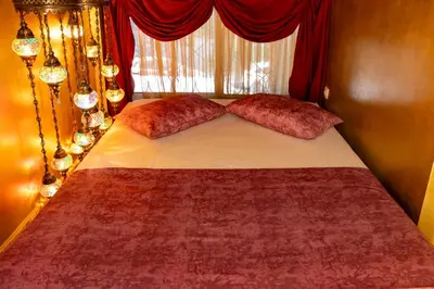 a bed with red pillows in a bedroom with a window at 1001 Nights - Low Celling Studio in downtown in Athens