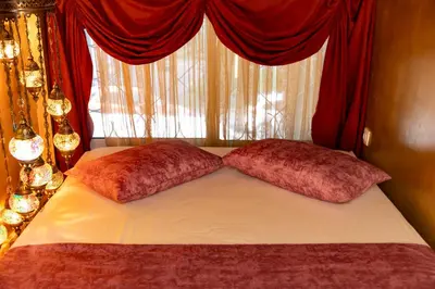 two pillows on a bed in front of a window at 1001 Nights - Low Celling Studio in downtown in Athens