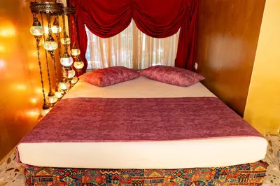 a bed with two red pillows and a window at 1001 Nights - Low Celling Studio in downtown in Athens