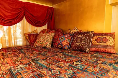 a bed with colorful pillows on it in a bedroom at 1001 Nights - Low Celling Studio in downtown in Athens