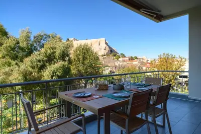 a table on a balcony with a view of a city at Stunning Acropolis 2 bedroom Opulence in Athens