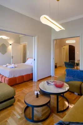 a living room with a bed and a table at Stunning Acropolis 2 bedroom Opulence in Athens
