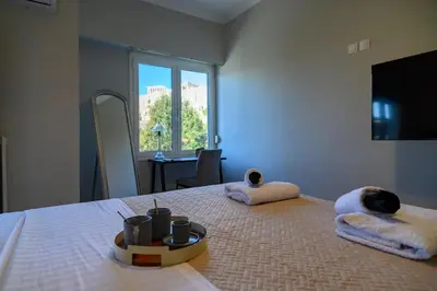 a bedroom with a bed with towels and a window at Stunning Acropolis 2 bedroom Opulence in Athens