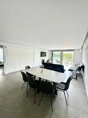 a dining room with a table and chairs and a couch at Athens Riviera Lux Flat, Lemos Vouliagmeni in Athens