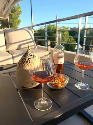 two wine glasses sitting on a table on a balcony at Athens Riviera Lux Flat, Lemos Vouliagmeni in Athens