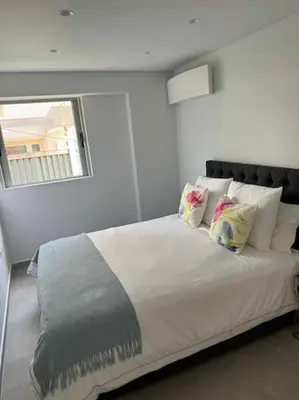 a bedroom with a large bed with pillows and a window at Athens Riviera Lux Flat, Lemos Vouliagmeni in Athens