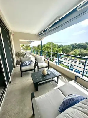 a balcony with a couch and a table on a building at Athens Riviera Lux Flat, Lemos Vouliagmeni in Athens