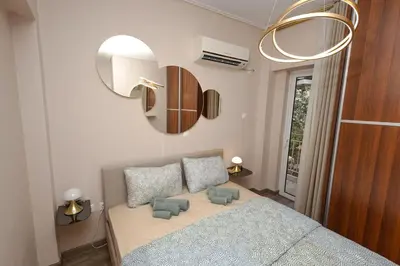 a bedroom with a bed with two pillows and a mirror at Summer flat by the beach&Taverna in Piraeus