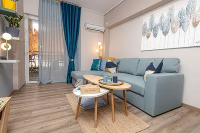 a living room with a blue couch and a table at Summer flat by the beach&Taverna in Piraeus