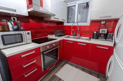a red and white kitchen with a sink and a microwave at Summer flat by the beach&Taverna in Piraeus