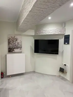 a living room with a flat screen tv on a wall at Oasis of Ralaxation in Athens in Athens