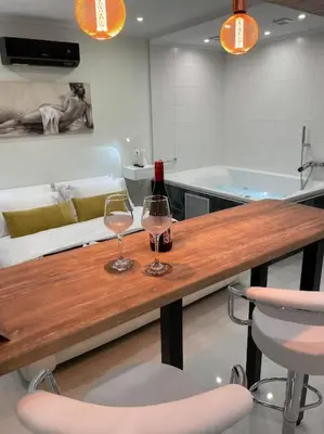 two glasses of wine on a wooden table in a kitchen at Oasis of Ralaxation in Athens in Athens