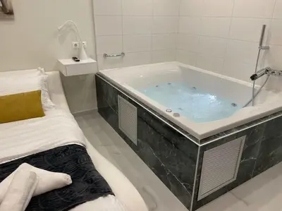 a bathroom with a tub with blue water in it at Oasis of Ralaxation in Athens in Athens