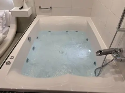 a bath tub filled with water in a bathroom at Oasis of Ralaxation in Athens in Athens