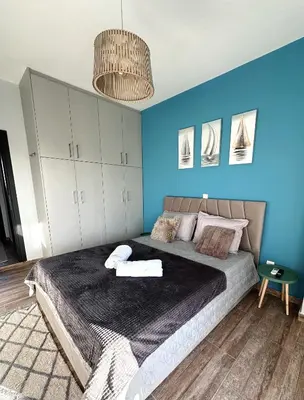 a bedroom with a large bed with a blue wall at Glyfada center seaview B in Athens