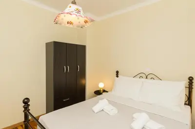 a bedroom with a large white bed and a black cabinet at Acropolis Aura Vintage Stays in Athens in Athens